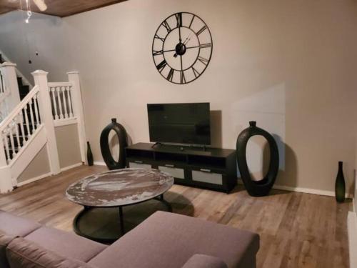 a living room with a large clock on the wall at ☆☆ Modern Coed Dorm in Harrisburg ☆☆ in Harrisburg