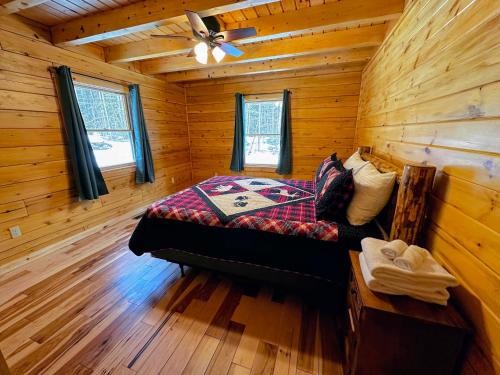 sypialnia z łóżkiem w drewnianym domku w obiekcie 65PT New Log Cabin in Private Setting. Hot tub. Gym/Pool Access! w mieście Twin Mountain