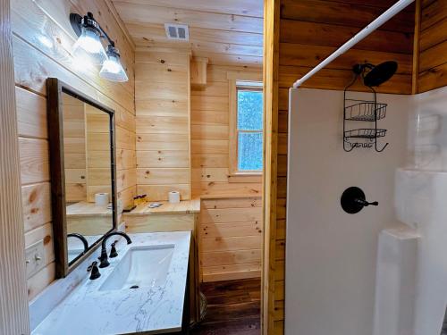 La salle de bains est pourvue d'un lavabo et d'un miroir. dans l'établissement 65PT New Log Cabin in Private Setting. Hot tub. Gym/Pool Access!, à Twin Mountain