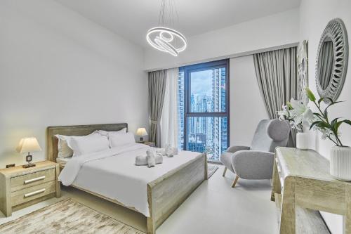 1 dormitorio blanco con 1 cama y 1 silla en MAJESTIC Act Two 2BR- 27th Floor Burj Khalifa- Downtown Dubai, en Dubái