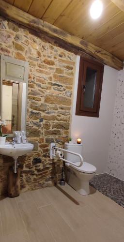 a stone bathroom with a toilet and a sink at la solana del abuelo Andrés in La Chana
