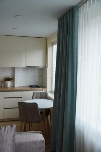 a kitchen with a table and chairs and a window at Studio Anna in Panevėžys