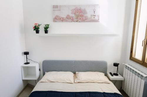 um quarto com uma cama com duas plantas na parede em CasaRiso em Grammichele