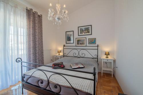 a bedroom with a bed and a chandelier at Hotel Villa Vera 2 in Fažana