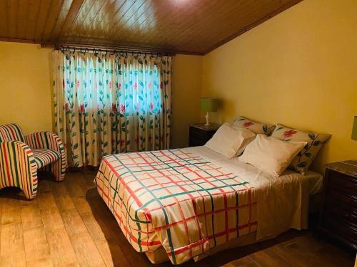 um quarto com uma cama e uma janela com cortinas em Quinta da Memória Village em Vimieiro