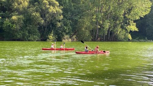 um grupo de pessoas em caiaques vermelhos em um lago em Quinta da Memória Village em Vimieiro