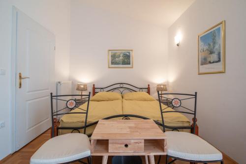 a bedroom with a bed with a table and two stools at Hotel Villa Vera 2 in Fažana