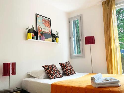 une chambre avec un lit avec deux lampes et une fenêtre dans l'établissement Groovy by Yumē, à Toulouse