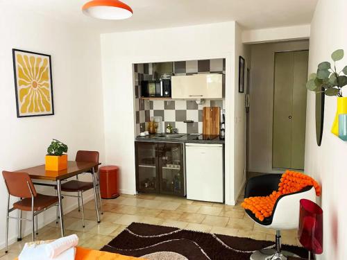 un salon avec une table et une cuisine dans l'établissement Groovy by Yumē, à Toulouse