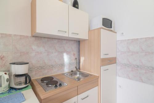 a small kitchen with a sink and a microwave at Hotel Villa Vera 2 in Fažana
