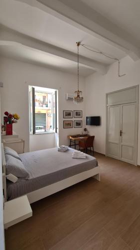 Un dormitorio blanco con una cama grande y una mesa en Giachery House Palermo, 4 min. dalla stazione Giachery en Palermo