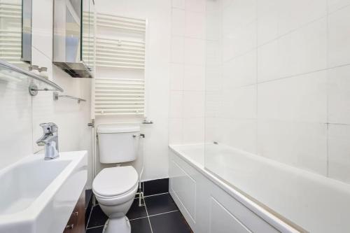 a bathroom with a toilet and a sink and a tub at Crouch End- 1 Bed Apartment in London