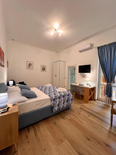 um quarto com uma cama, uma secretária e uma televisão em ERIC'S HOUSE em Salerno