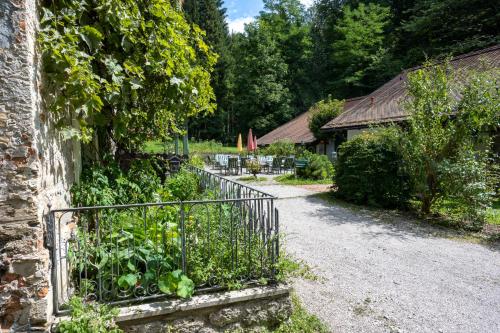 a garden with a metal fence and vegetables at Naturidyll Hotel Hammerschmiede in Anthering