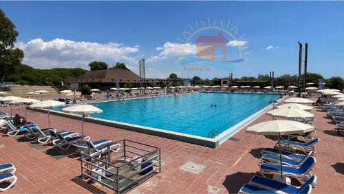 a large swimming pool with chairs and umbrellas at Casa vacanze Kastalia - Blu in Ragusa