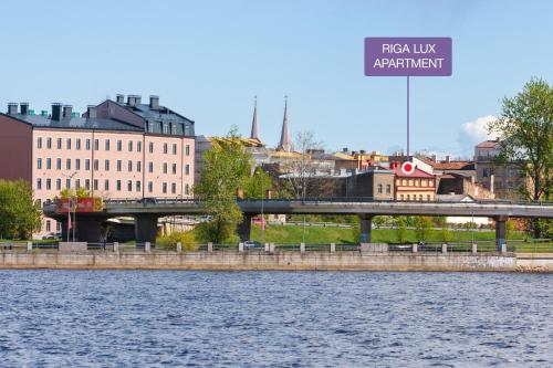 un puente sobre un río con edificios en el fondo en DaugavaLuxApartments Free Parking, en Riga