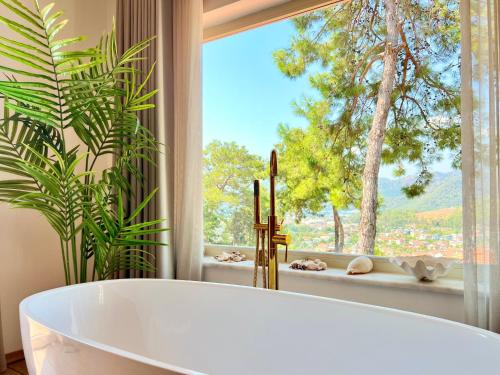 a bath tub in a bathroom with a window at Villa Storm - Very Stylish Villa w/Pool & Garden in Gocek Hills in Fethiye