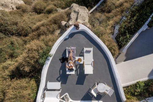 an overhead view of a swimming pool with people on it at Diamond Luxury Suites Collection in Oia