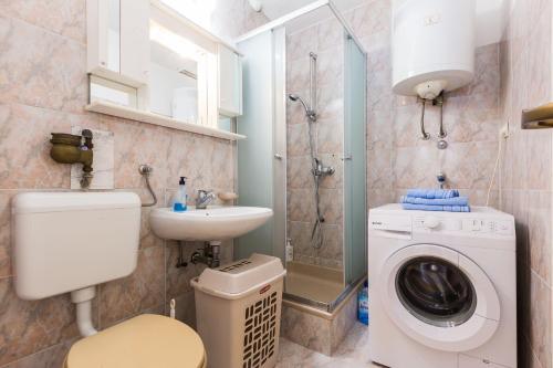 a bathroom with a washing machine and a sink at Great view apartment in Zadar
