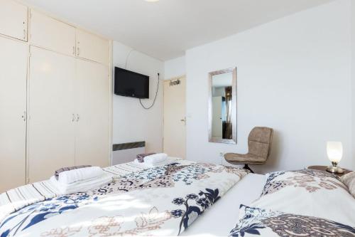 a bedroom with two beds and a chair at Great view apartment in Zadar