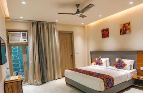 um quarto com uma cama e uma ventoinha de tecto em HOTEL GLOBAL CORPORATE NOIDA em Noida