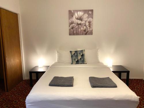 a bedroom with a white bed with two tables at Alina & Fanny - Philadelphia Convention Center in Philadelphia