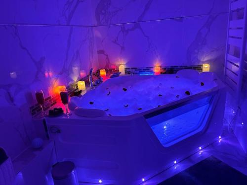a room with a bed with purple lights in it at Luxueux Appartement Jacuzzi proche de Paris in La Celle-Saint-Cloud