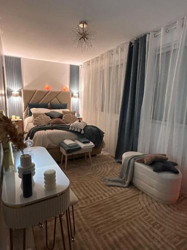 une chambre avec un lit et une table dans une pièce dans l'établissement Luxueux Appartement Jacuzzi proche de Paris, à La Celle-Saint-Cloud