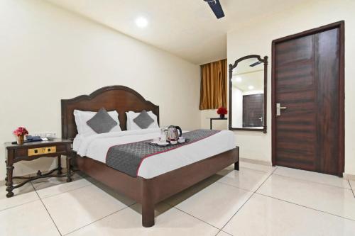 a bedroom with a bed and a wooden door at OYO Townhouse 998 Hotel Monark in Jaipur