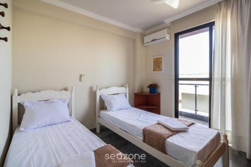 2 camas en una habitación con ventana en Cobertura c/ vista para mar em Cabo Frio/RJ IBZ402 en Cabo Frío