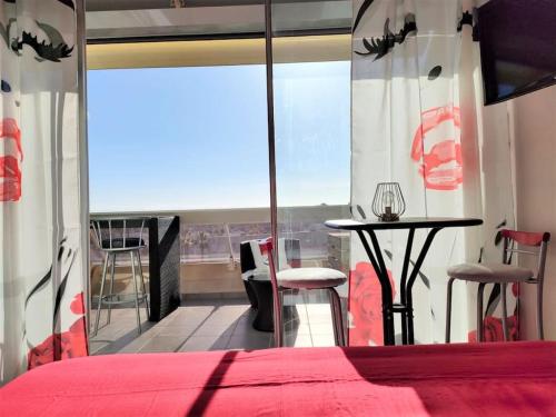 une chambre avec un lit, une table et une fenêtre dans l'établissement Studio 411, Héliopolis AB au village naturiste, au Cap d'Agde