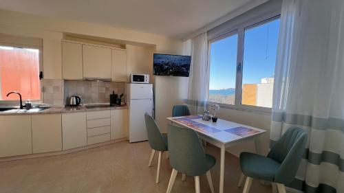 cocina con mesa, sillas y ventana en Ludmila Apartment, en Durrës