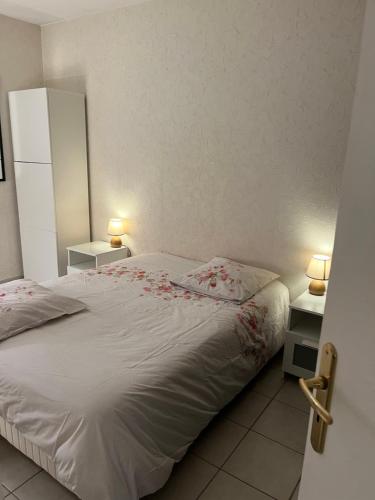 a bedroom with a bed with flowers on it at Appartement T2 avec Terrasse centre ville d’Aix en Provence in Aix-en-Provence