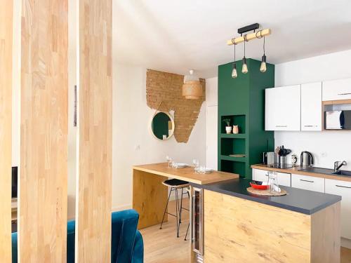 - une cuisine avec un comptoir en bois et un mur vert dans l'établissement Péri by Yumē, à Toulouse