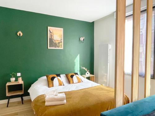 - une chambre dotée d'un lit avec un mur vert dans l'établissement Péri by Yumē, à Toulouse