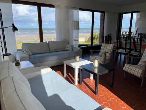 a living room with a couch and a table at Villa d'architecte - Les Pieds dans l'Eau in Ver-sur-Mer