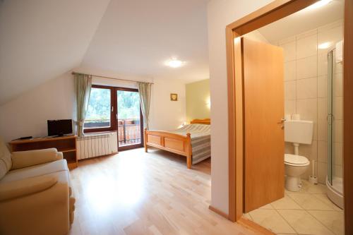 Dieses Zimmer verfügt über ein Bad mit einem Bett und einem WC. in der Unterkunft Prenočišča Valentina in Solčava