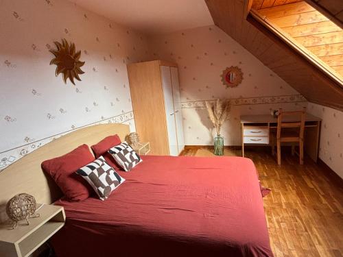 - une chambre mansardée avec un grand lit rouge dans l'établissement LE RAYON DE SOLEIL, à Froberville