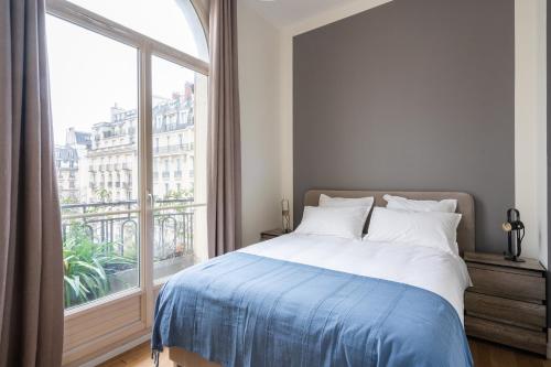 une chambre avec un lit et une grande fenêtre dans l'établissement Luxury 4 Bedroom Eiffel Tower View, à Paris