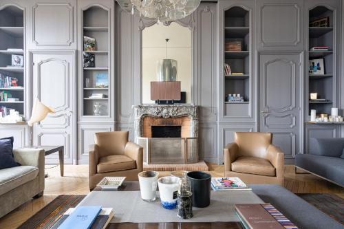 a living room with a couch and a fireplace at Luxury 4 Bedroom Eiffel Tower View in Paris