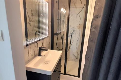 une salle de bain avec un lavabo blanc et une douche dans l'établissement Studio 43, Héliopolis L au village naturiste, au Cap d'Agde