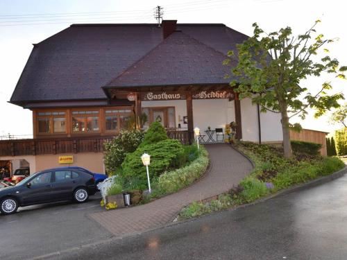 a house with a car parked in front of it at Gasthaus Pension Heidhof in Freiamt