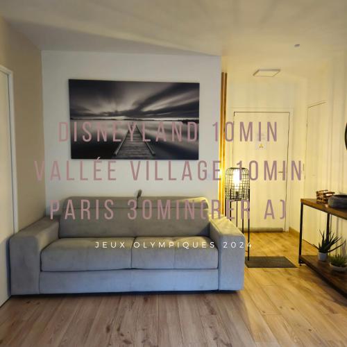 un salon avec un canapé et un tableau au mur dans l'établissement Le splend'id disneyland, à Chessy