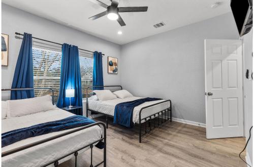 2 camas en una habitación con cortinas azules en Charming Walkable 4 BR2.5 BA Near Dtown Riverwalk en San Antonio