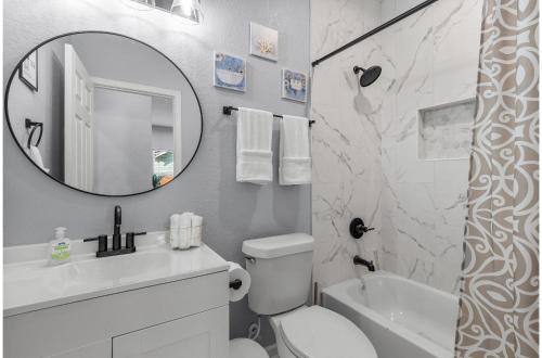 Baño blanco con lavabo y espejo en Charming Walkable 4 BR2.5 BA Near Dtown Riverwalk en San Antonio