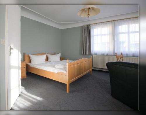 a bedroom with a bed and a couch at Hotel Roß in Zwönitz