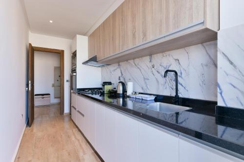 a kitchen with black and white marble countertops at Appartement Charmant & Cozy - Centre ville de Rabat in Rabat