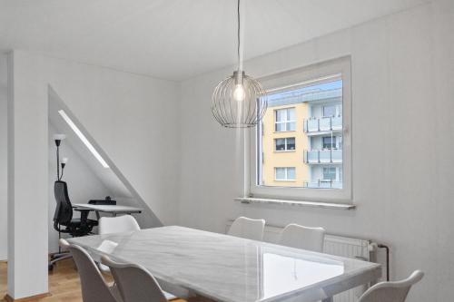 a dining room with a table and chairs and a window at Skyview Retreat Maisonette in Essen