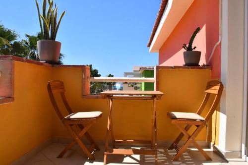 un patio con 2 sillas y una mesa en el balcón en Kyaala Djadsal Moradias pool&sea, en Santa Maria
