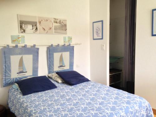 - une chambre avec un lit bleu et 2 oreillers bleus dans l'établissement Maison cosy entre vignes et plage, à Dolus-d'Oléron